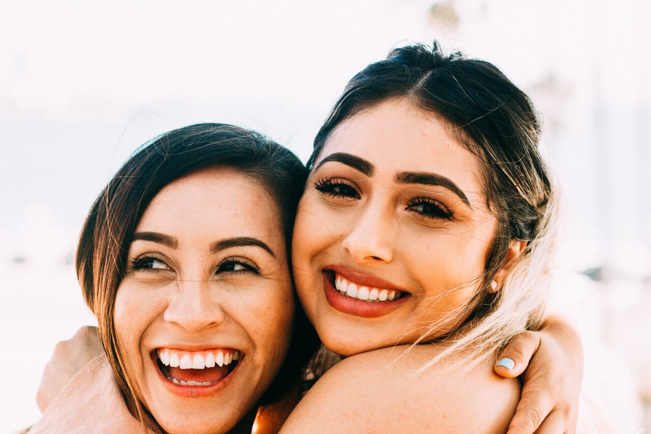 two girls smiling and embracing