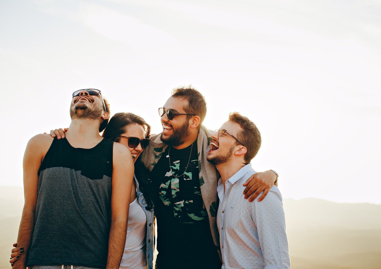friends holding each other laughing in a group