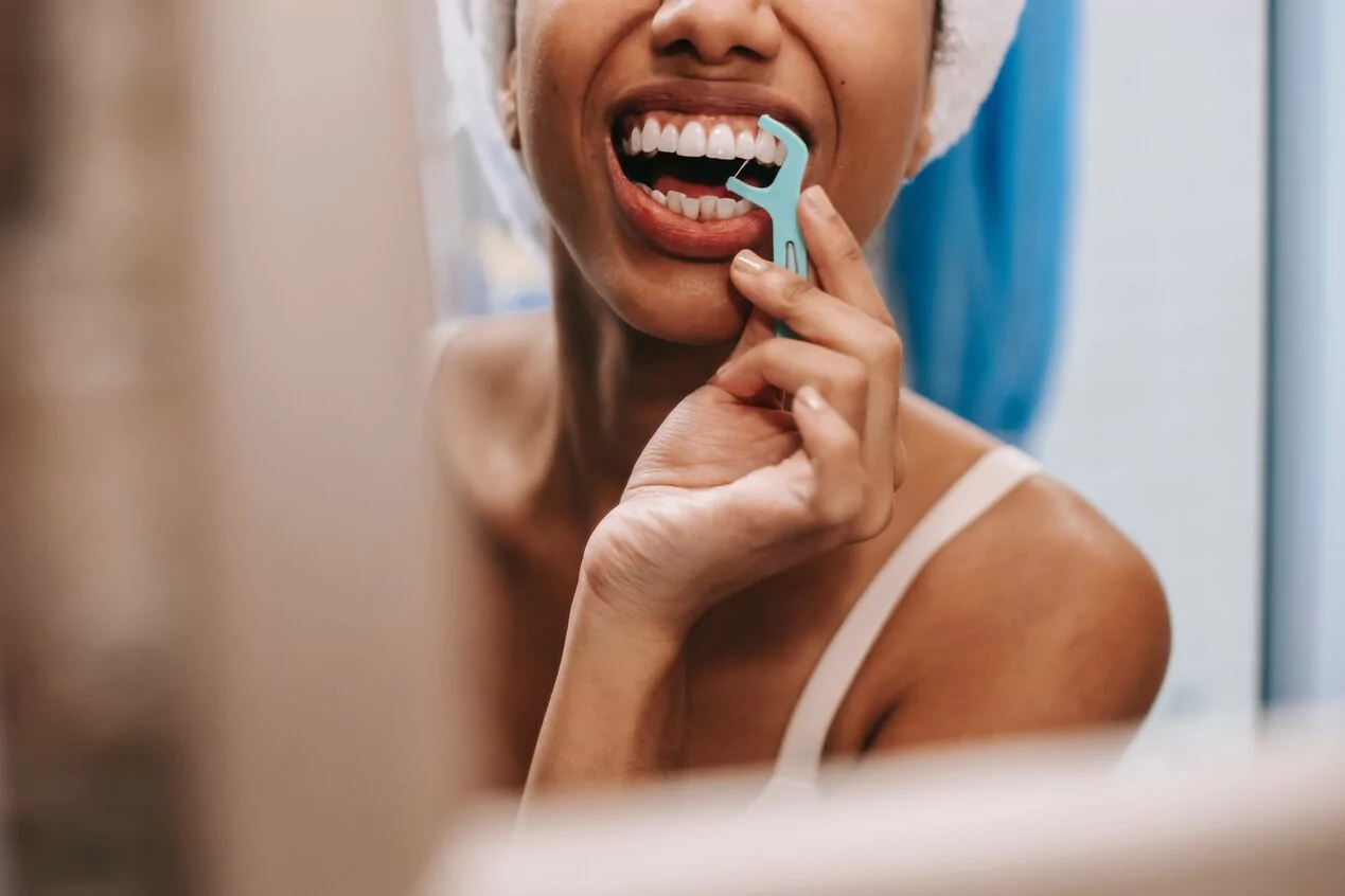 girl flossing in the mirror