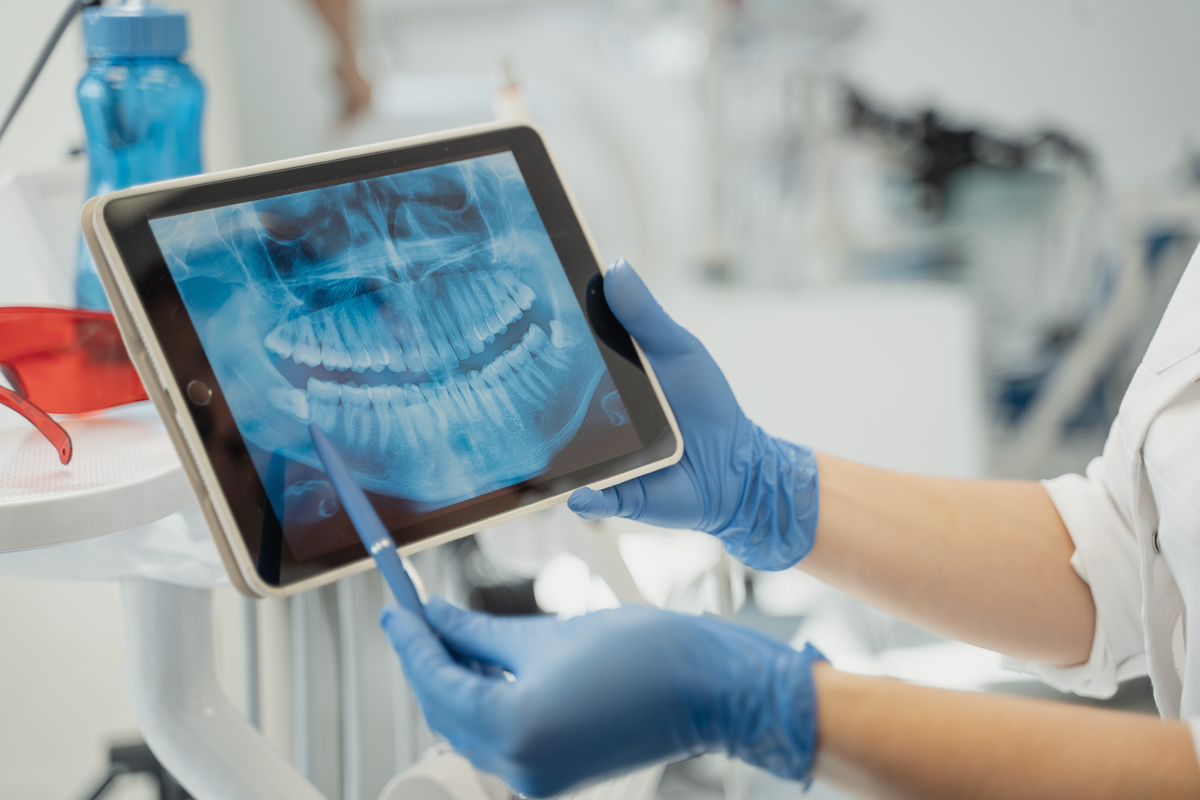 Dentist showing x-ray to patient on tablet